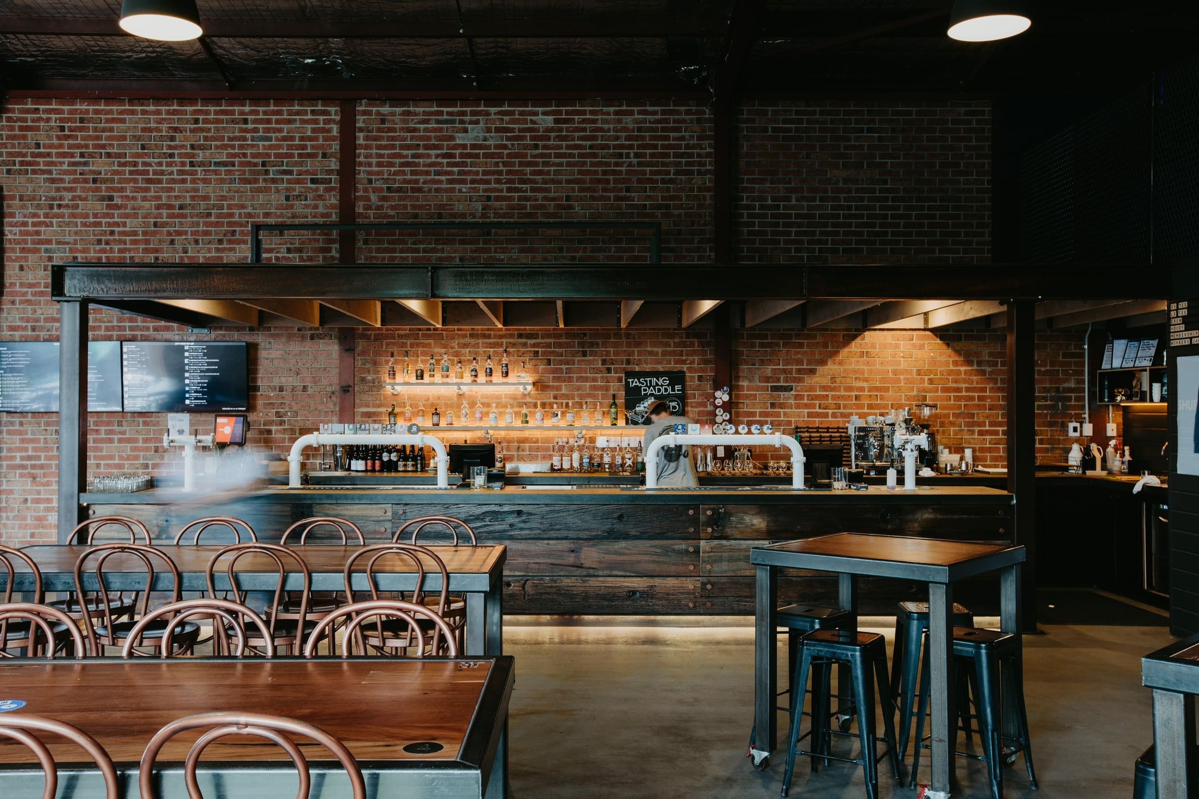 Brick-walled pub bar with tap towers, ready for service