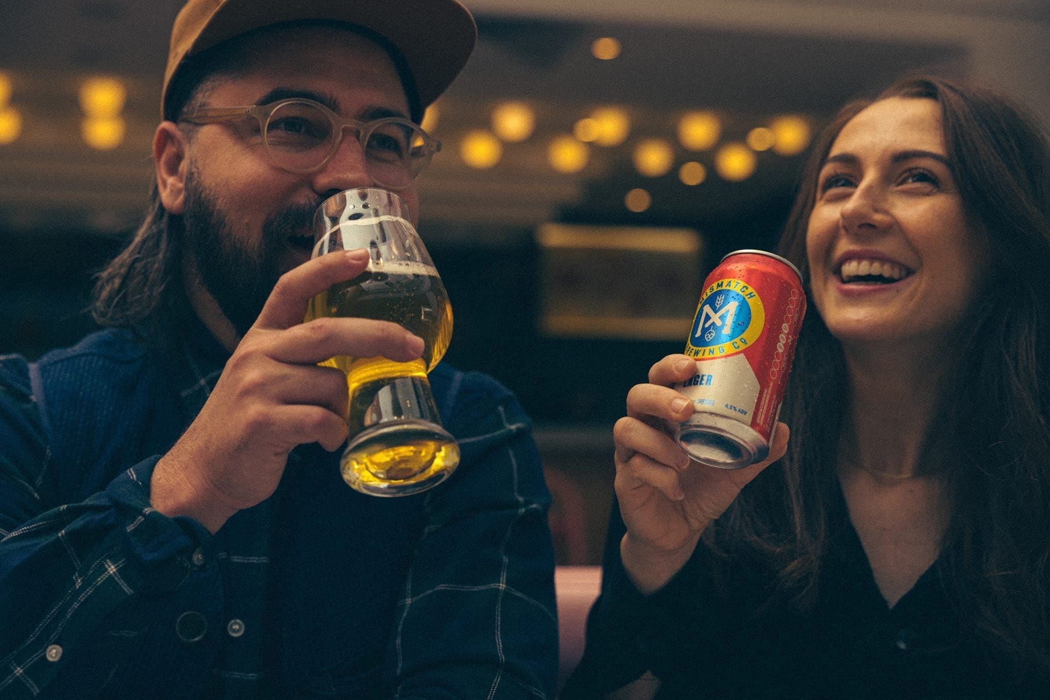 Couple laughing at the bar with a Mismatch can