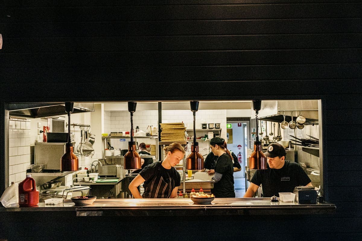 Chefs working the pass in an open pub kitchen